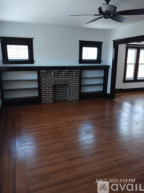 A room with wooden floors and a brick fireplace.