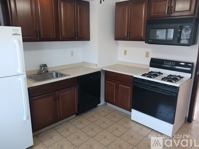 A kitchen with brown cabinets and a white fridge.