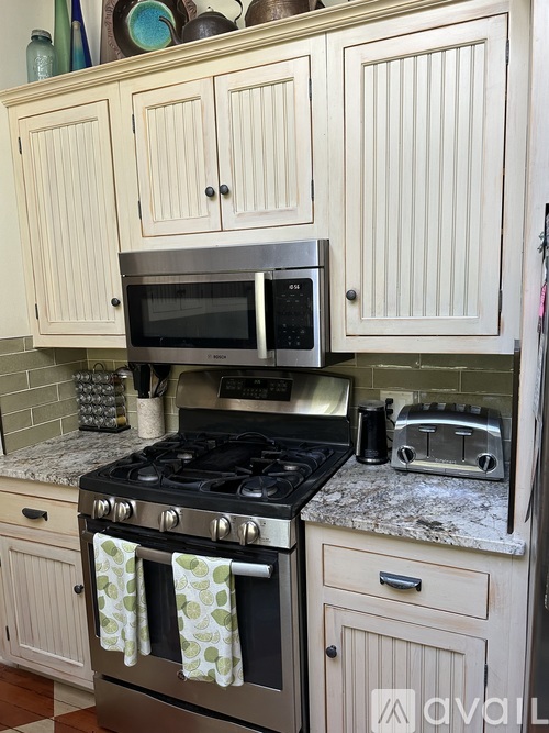 A kitchen with a black stove top and a microwave above it.
