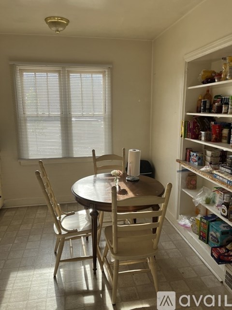A kitchen with a table and chairs.