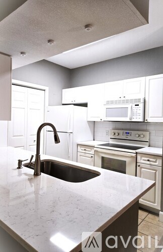 A kitchen with a sink and a microwave on the counter.
