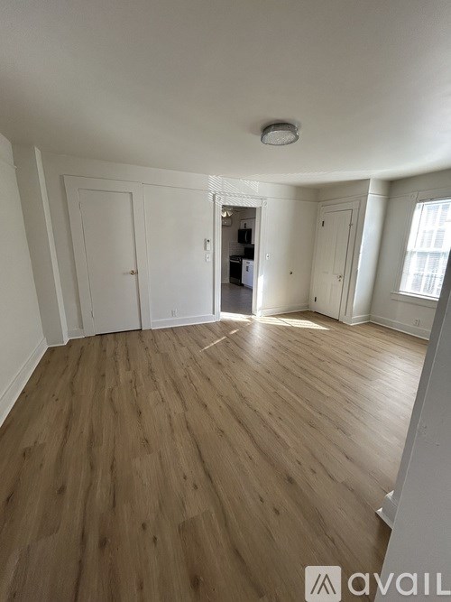 A room with wooden flooring and white walls.