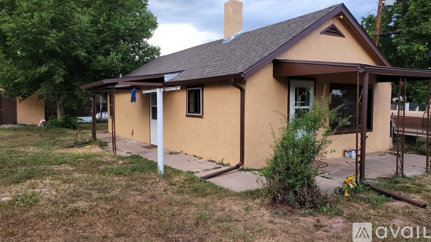 A yellow house with a green garage door is for sale.
