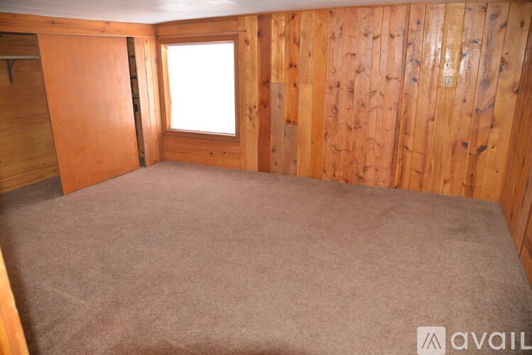 A room with wooden walls and carpeted floor.