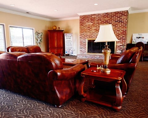 a living room with leather furniture and a brick fireplace
