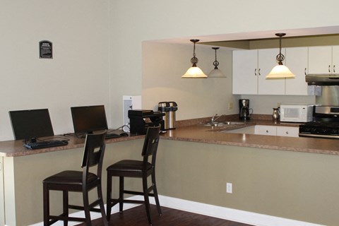 a kitchen with a counter top with two chairs