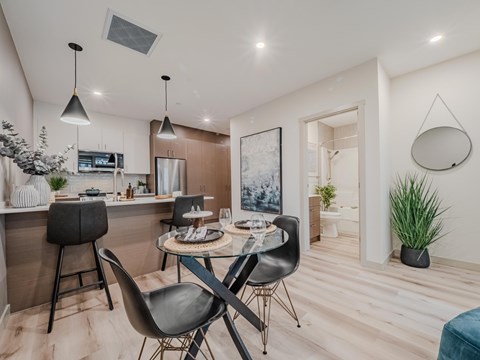 A modern kitchen with a dining table and chairs.