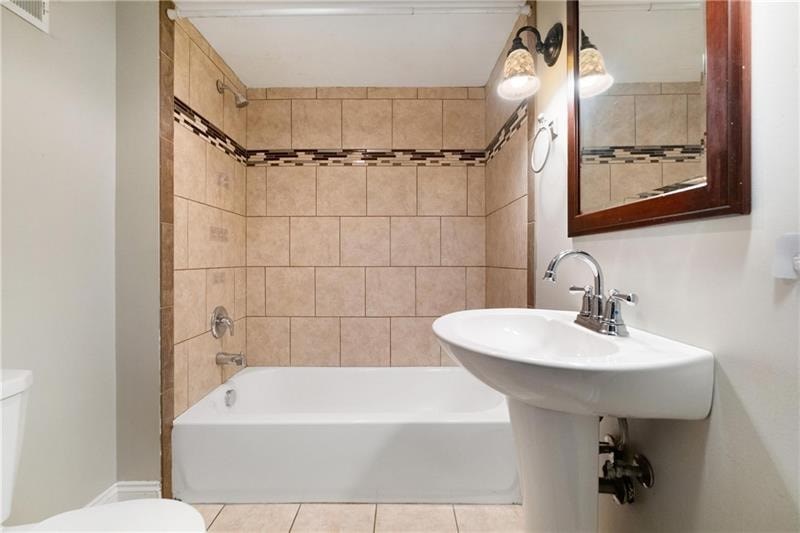 A bathroom with a white tub and sink.