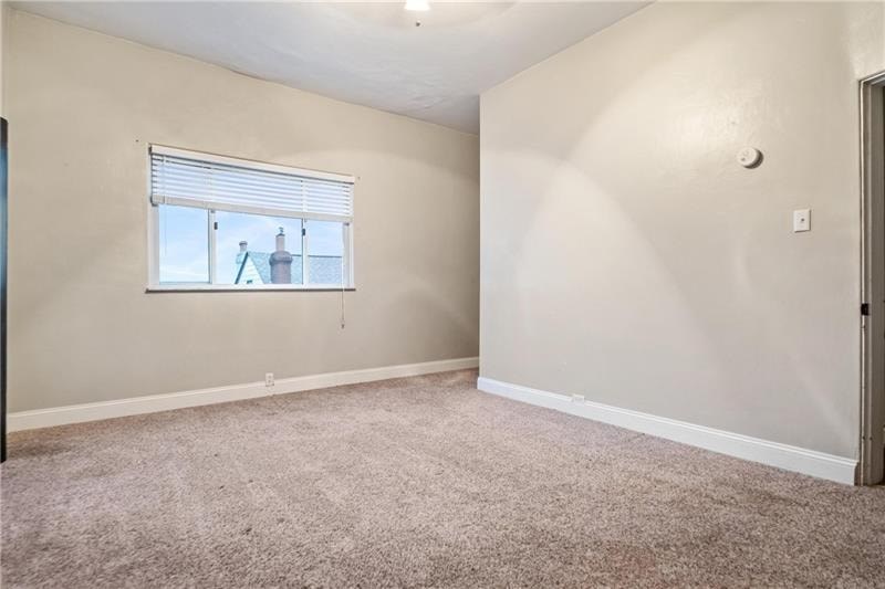 A room with a window and carpeted floor.