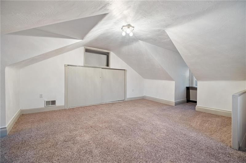 A room with a carpeted floor and a window on the wall.