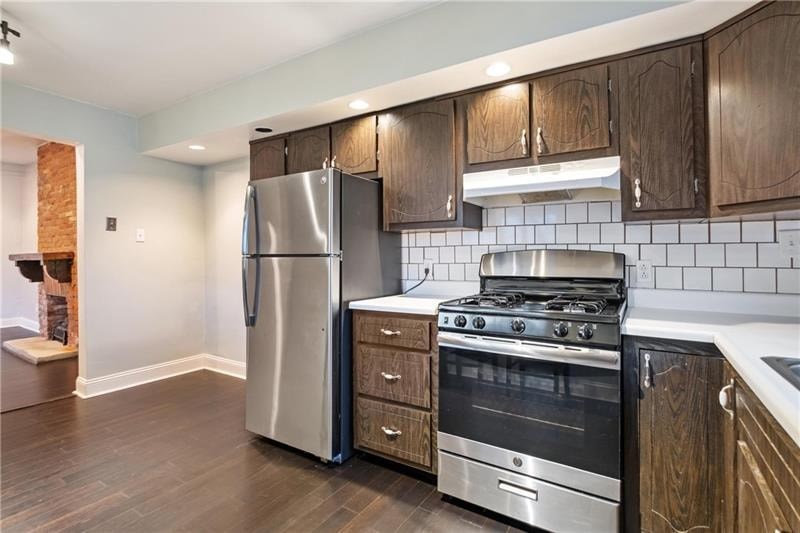 A kitchen with a stainless steel refrigerator and oven.