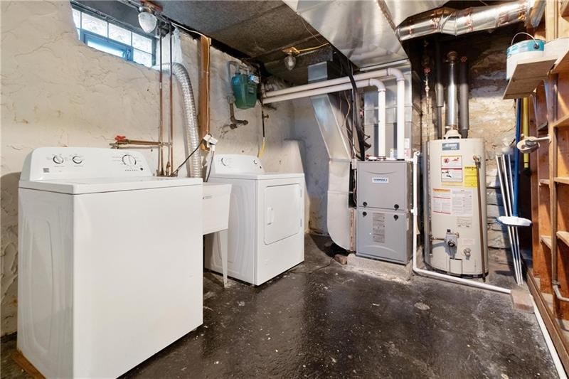 A room with a washer and dryer and a furnace.