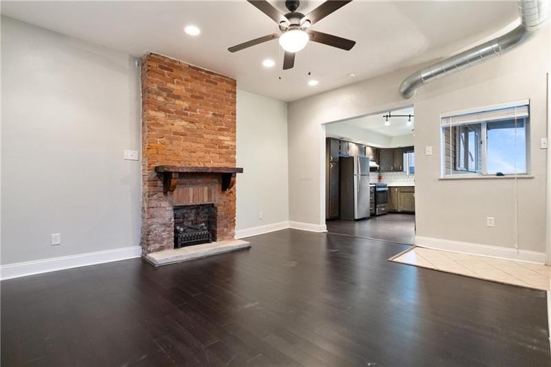 A room with a fireplace and a ceiling fan.