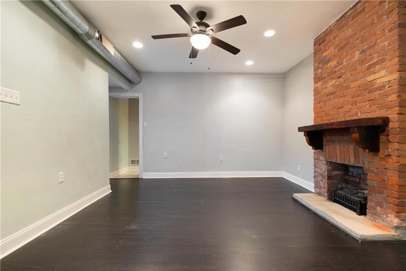 A room with a fireplace and a ceiling fan.