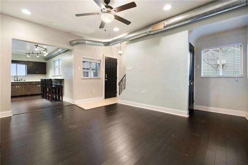 A room with a ceiling fan and wooden flooring.
