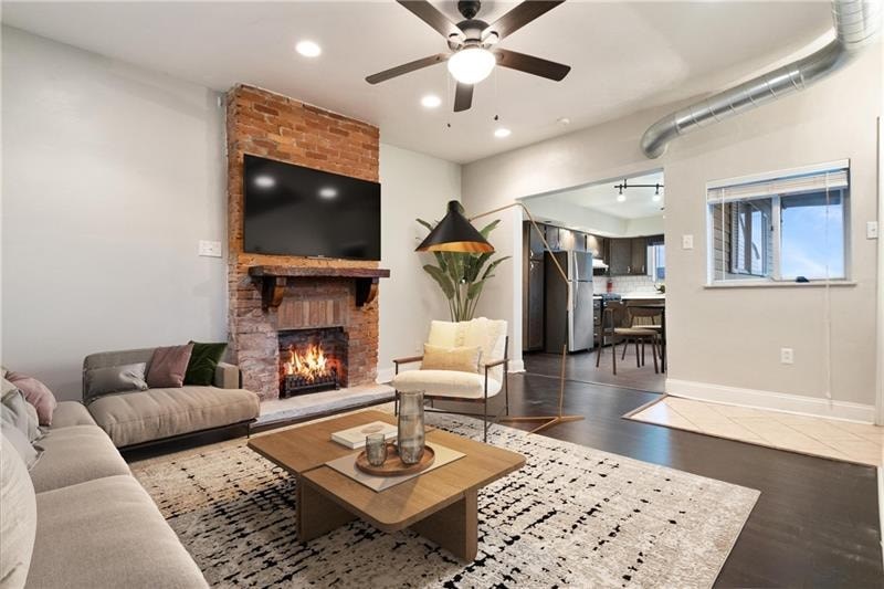 A living room with a fireplace and a television on the wall.