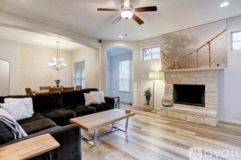 A living room with a black couch and a wooden coffee table.