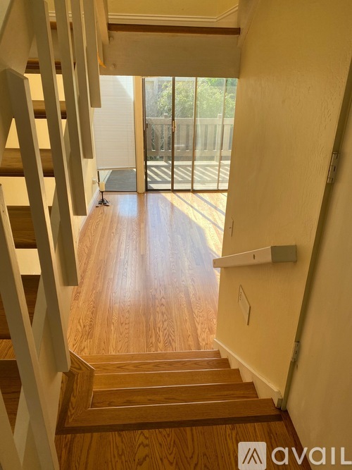 A wooden staircase with a metal railing leads to a balcony.