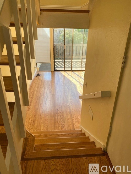 A wooden staircase with a metal railing leads to a balcony.