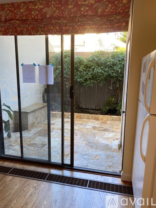 A glass door with a red curtain and a sign on it.