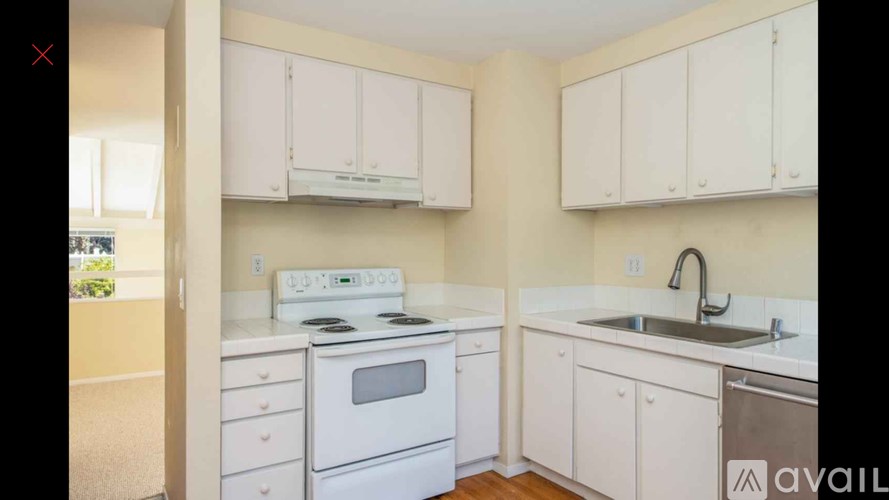 A kitchen with white appliances and cabinets.