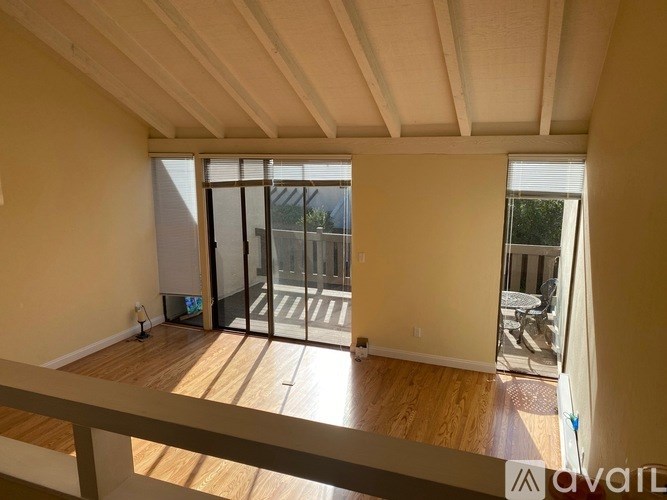 A room with a balcony and sliding glass doors.