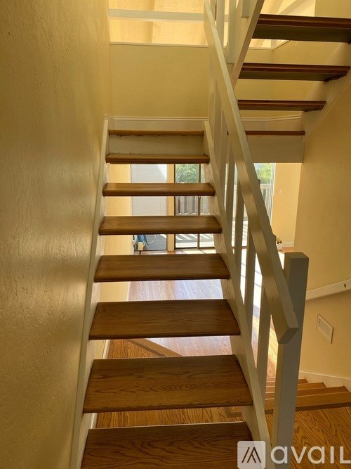 A wooden staircase with a metal railing.