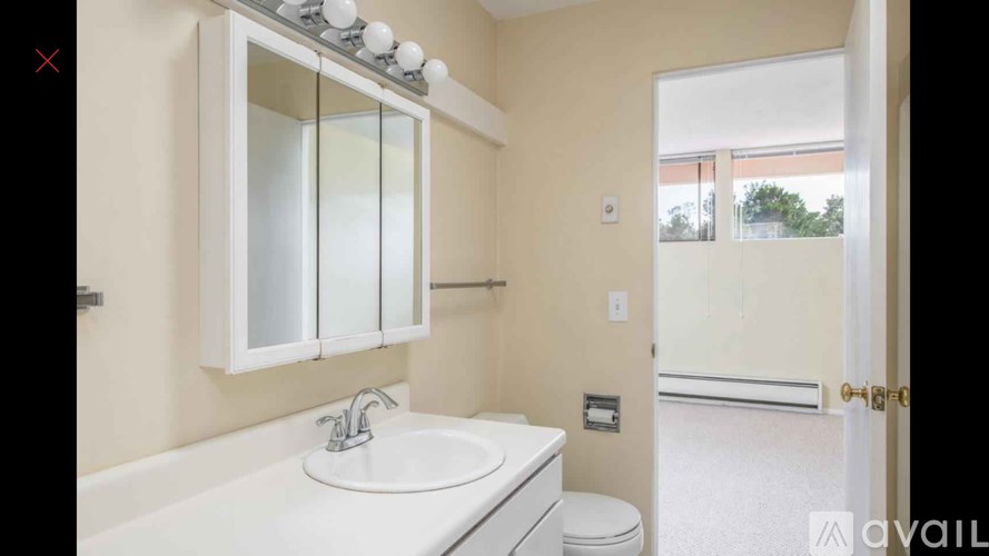 A bathroom with a sink, mirror, and toilet.