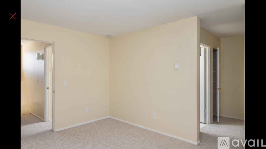A room with beige walls and carpeted floor.