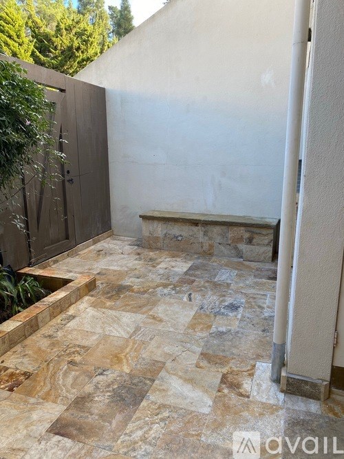 A patio with a stone floor and a wooden door.