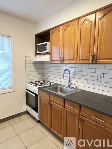 A kitchen with wooden cabinets and a white stove top oven.