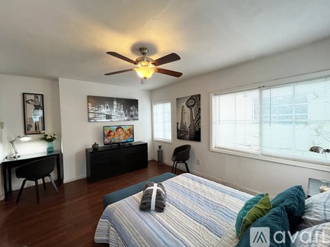A bedroom with a bed, desk, and chair.