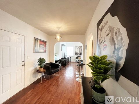 A living room with a couch, chairs, and a potted plant.