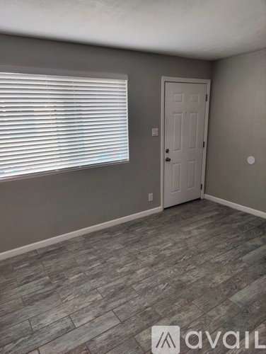 A room with a door and a window with blinds.