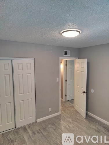 A room with a white door and a light on the ceiling.