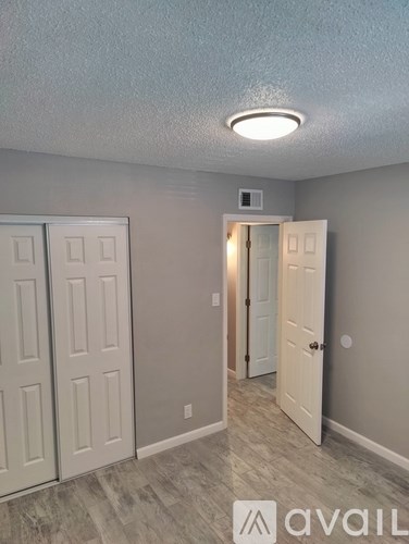 A room with a white door and a light on the ceiling.