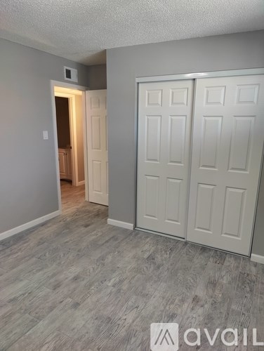 A room with a white door and a grey wall.
