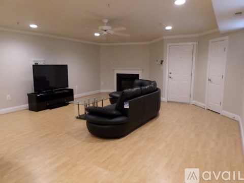 A living room with a black couch and a television.