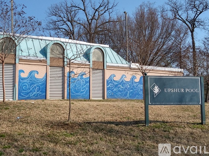 A building with a blue roof and a sign that says "UPSHUR POOL".