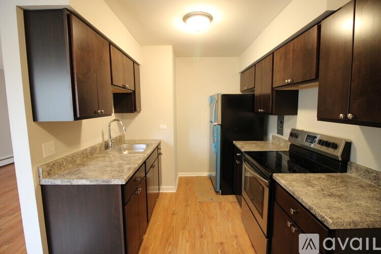 A kitchen with black appliances and brown cabinets.