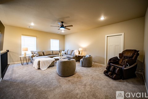 A living room with a brown chair and a grey ottoman.