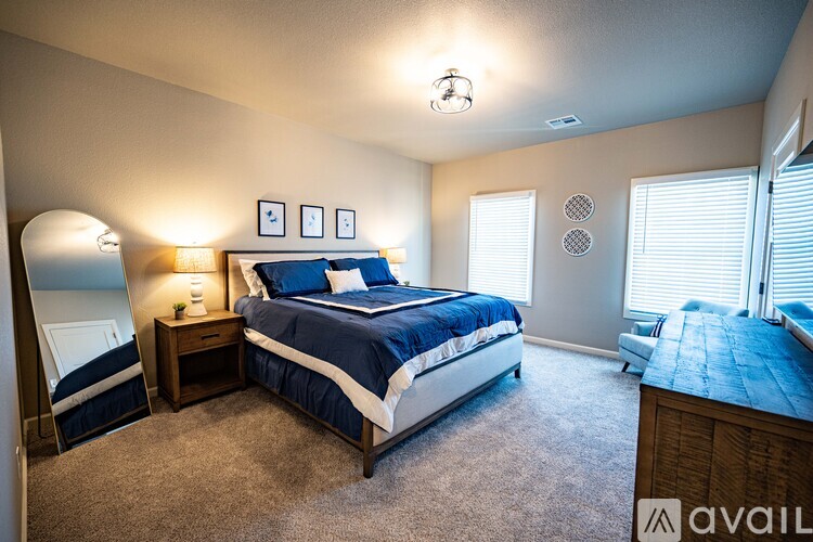 A bedroom with a large bed and a nightstand with a lamp.