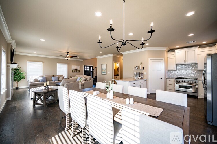 A modern kitchen with a dining table and chairs in the foreground.