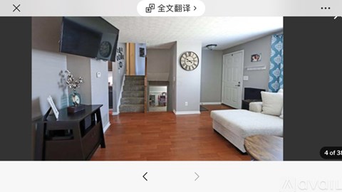 A living room with a staircase in the background.