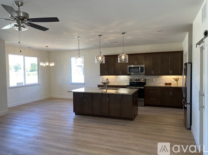A spacious kitchen with dark wood cabinets and a central island.