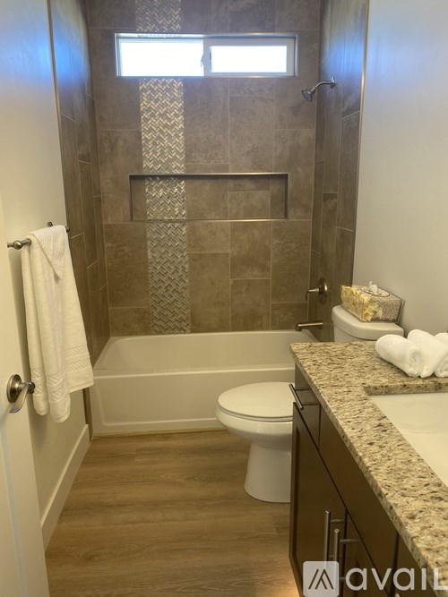 A bathroom with a toilet, sink, and a shower with a glass door.