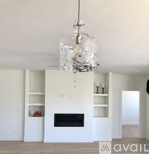 A modern living room with a fireplace and a chandelier.