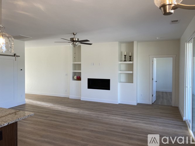 A spacious living room with a fireplace and built-in shelves.