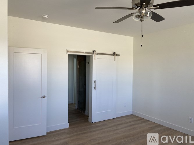 A room with a ceiling fan and a sliding door.