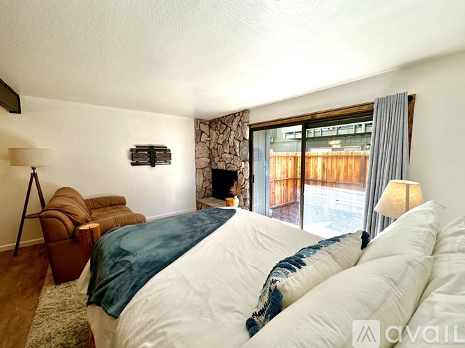 A bedroom with a large bed and a chair.